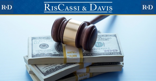 Judge's gavel on top of $100 bills